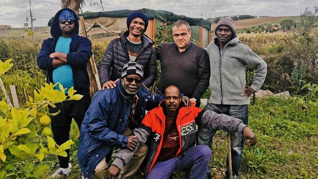 Don Antonio Polidoro con alcuni migranti